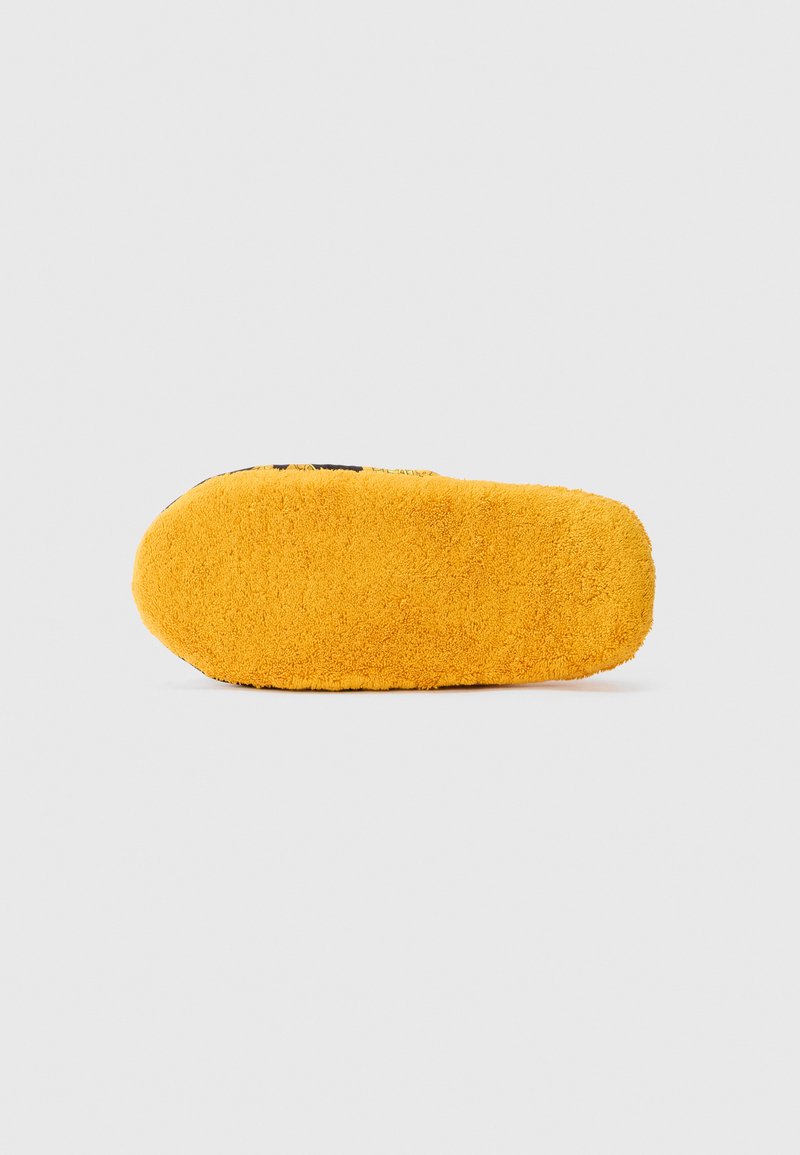 Bright yellow fuzzy slipper sole with a soft textured surface, lying flat against a plain white background.
