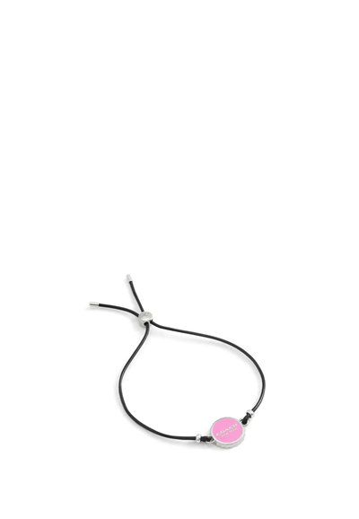 Bracelet en cuir noir avec liens ajustables, présentant un accent rond en argent avec une étiquette circulaire rose portant "COACH" en texte blanc.