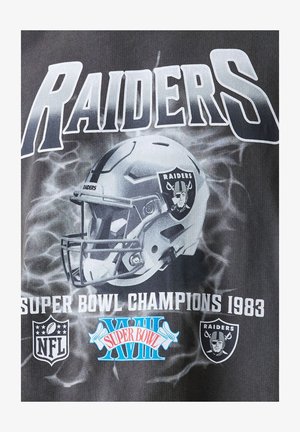 Black fabric t-shirt featuring a Raiders helmet graphic, "RAIDERS" text, and "SUPER BOWL CHAMPIONS 1983" in white. NFL logos included.