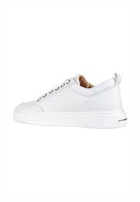 Sneaker bianco in pelle con texture liscia, punta arrotondata, suola piatta e occhielli in argento. Dotato di un tab sul retro e branding minimale.