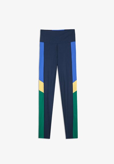 Námořnické legíny s vysokým pasem, které mají modré, žluté a zelené barevné bloky podél vnějších nohavic.