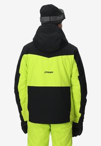 Spyder Ski-Jacke in Schwarz und leuchtendem Neon-Grün, mit Kapuze, kontrastierendem Paneldesign und Logo auf der Rückseite. Texturiertes Material.