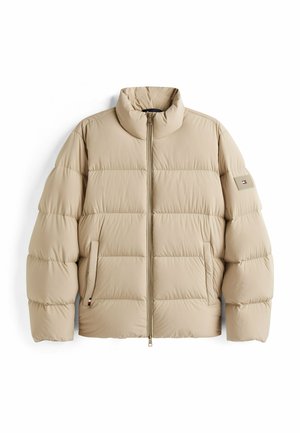 Beige pufferjack met een hoge kraag, doorgestikt ontwerp, zijzakken en een merkembleem op de linkermouw. Met ritssluiting aan de voorkant.