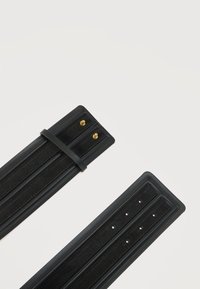 Δύο μαύρα δερμάτινα λουράκια ρολογιού με χρυσά καρφιά σύνδεσης και πολλαπλές τρύπες ρύθμισης πάνω σε λευκό φόντο.