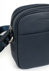 Borsa a tracolla in pelle blu navy con superficie testurizzata, forma rettangolare, chiusura con zip, tracolla regolabile e dettagli in metallo.