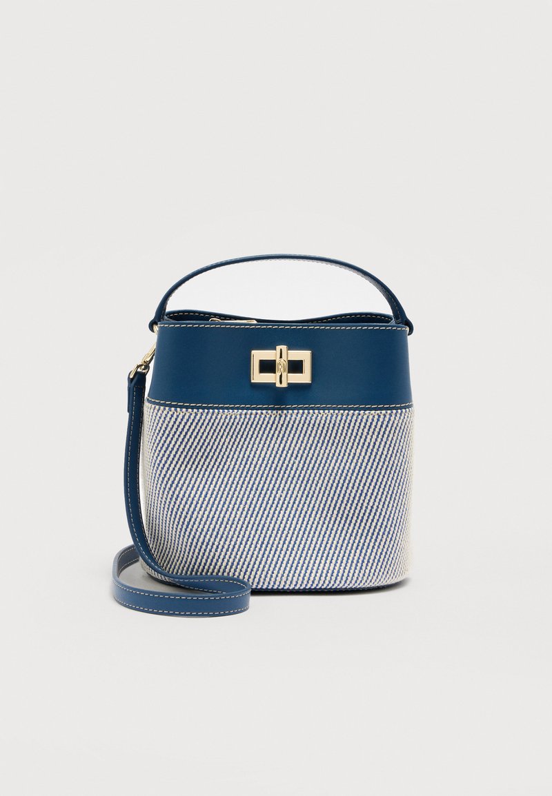 Τσάντα χειρός τύπου κάδος με μπλε και άσπρες ρίγες, χειρολαβή στο πάνω μέρος, αποσπώμενο λουρί ώμου και κούμπωμα με χρυσό περιστρεφόμενο κλείσιμο σε μονόχρωμο φόντο.