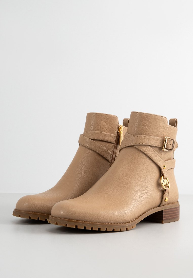 Helle Leder-Ankle-Boots mit einer strukturierten Oberfläche, seitlichem Reißverschluss, verstellbarem Riemen mit goldenen Beschlägen und einem niedrigen Holzabsatz.