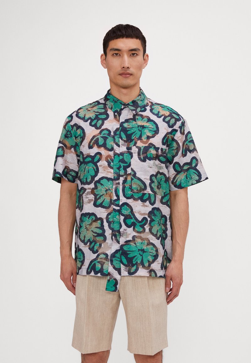 Short-sleeve shirt made of lightweight fabric, featuring a multi-colored floral pattern with green, blue, and brown accents on a light background.