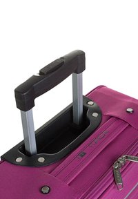 Maleta de ruedas morada con asa negra retráctil, acentos metálicos plateados, cierre de cremallera y superficie de tejido texturizado.