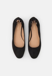 Ballerines en suédine noire avec un bout arrondi, doublure douce et élastique froncé à l'ouverture pour un ajustement parfait. Texture lisse sur tout le chaussant.