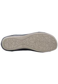 Mustan kengän pohja, jossa on teksturoitu beige kumipinta, jossa on kukkakuosi. Mukana brändin nimi "Josef Seibel" kohopainettuna.