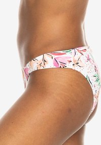 Blumen-Bikiniunterteil mit weißem Grund und pinken, grünen und orangenen Mustern. Glatte Textur, mittelhoch geschnittenes Design und minimale Abdeckung.