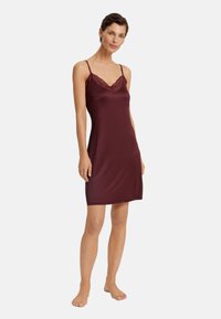 Abito di satin bordeaux con pizzo lungo il colletto. Presenta spalline sottili regolabili e una linea dritta, che termina sopra il ginocchio.