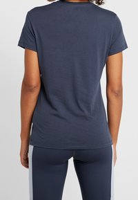 Tmavě modré bavlněné tričko s krátkým rukávem, kulatým výstřihem, volným střihem a hladkou, jednoduchou texturou.
