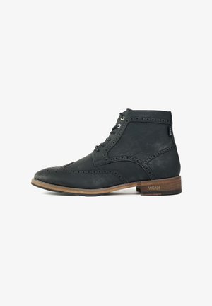 Black vegan leather ankle boot with brogue detailing, rounded toe, metal eyelets, and a tan wooden sole. Features logo on heel.