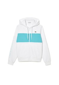 Sudadera con cremallera blanca que presenta una franja horizontal turquesa, bolsillos tipo canguro y un pequeño logo en el pecho. Incluye capucha con cordón.