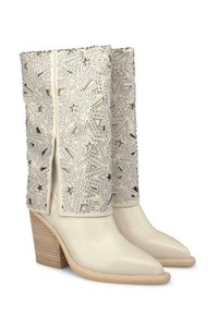 Stivaletti con tacco in pelle crema, con ritagli a forma di stella e dettagli in strass sul gambale. Tacco in legno a blocco.