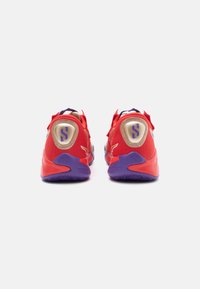Czerwone buty sportowe z fioletowymi akcentami. Oddychająca siateczka, wyściełany obcas z złotym detalem i logo, gumowa podeszwa z wzorem zwiększającym przyczepność.