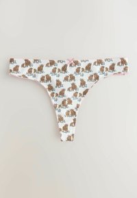 String blanc avec motif répétitif d'ours brun et de fleurs, bordé de dentelle rose clair et un petit nœud rose au centre de la ceinture.