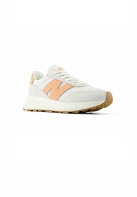Sneaker bianca con accenti pesca, caratterizzata da una tomaia texturizzata, colletto imbottito, lacci piatti e una suola in gomma spessa progettata per la trazione.