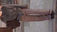 Brown faux fur jacket with a belt, paired with light brown tailored pants and dark brown suede shoes, held with a dark suede bag.