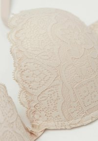 Blush spetsbh med scallopade kanter, blommönster och mjuk textur. Har justerbara remmar och ett hysse-och-krokstängning.