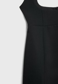 Robe noire sans manches avec corsage ajusté et jupe évasée, fermeture éclair latérale.