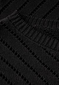 Schwarzer Strickstoff mit einem strukturierten Muster, das diagonale Rippungen und offene Gewebedetails aufweist, wobei eine weiche und faserige Textur zur Geltung kommt.