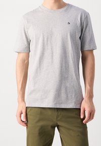 Grijze katoenen t-shirt met korte mouwen, ronde hals en een klein zwart logo op de linkerborst. Zachte textuur, casual ontwerp.