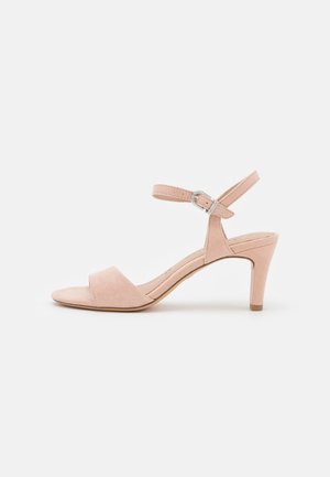 Nøgen ruskind sandal med høj hæl, bred tårem og justerbar ankelrem. Har en tynd hæl og et glat, minimalistisk design.