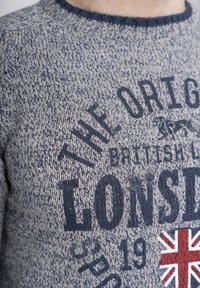 Maglione lavorato a maglia grigio e blu navy con colletto rotondo, tessuto texture e testo grafico con un accento della Union Jack.