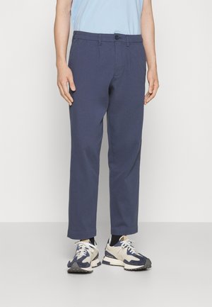 Námořnické chinos z bavlněné směsi se rovný fit, předními kapsami, zapínáním na knoflík a manžetami, stylizované s světlými sportovními teniskami.
