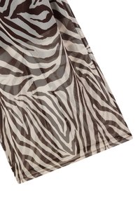 Tessuto semi-trasparente con stampa zebra, caratterizzato da strisce alternate marroni e crema, texture liscia e design leggero.