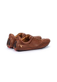 Braune Leder Schuhe mit genähtem Design, ausgestattet mit goldenen Akzenten, schwarzen Gummidetails an der Ferse und einer runden Zehenform.