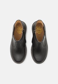 Mustat nahkakengät, joissa on sileä pinta, pyöreä kärki ja ommellut yksityiskohdat pohjassa, vetoketjukiinnitys jokaisella puolella.