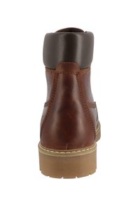 Brun læder ankelstøvle med en mørkebrun polstret krave, stikninger og en tekstureret gummisål. Bagfra fremhæves den skrånende form.