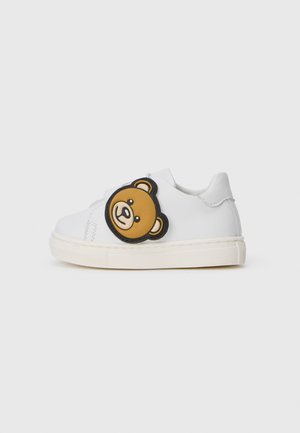 Białe sneakersy z gładką skórzaną cholewką, z dużą twarzą żółtego i brązowego misia po bokach oraz teksturowaną gumową podeszwą.