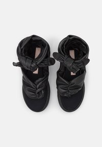 Czarne skórzane sandały z plecioną konstrukcją, miękką cholewką i gładką wkładką. Posiadają czarną podeszwę i minimalne okucia.