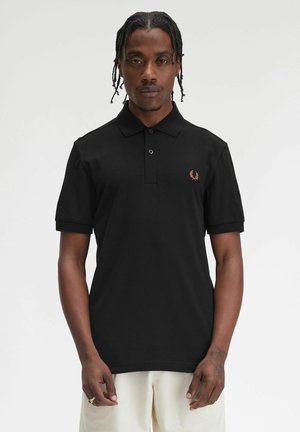 Polo shirt nera in cotone, con colletto a bottoni, maniche corte e un piccolo design ricamato sul lato sinistro del petto.