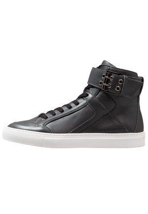Schwarze High-Top-Sneaker aus Leder mit weißer Gummisohle. Sie verfügen über einen Knöchelriemen mit Metallbeschlägen und ein strukturiertes Seitenpanel-Design.