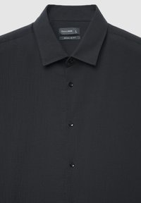 Schwarzes Hemd mit Knopfleiste und regulärer Passform. Verfügt über einen strukturierten Stoff, einen weichen Kragen und fünf schwarze Knöpfe entlang der vorderen Knopfleiste.