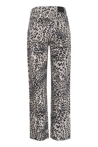 Pantaloni a gamba larga in un tessuto beige chiaro con motivo a stampa leopardata nera. Include tasche posteriori e un'etichetta in vita nera.