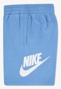 Μπλε βαμβακερά σορτς με ελαστική μέση, που φέρουν ένα λευκό λογότυπο Nike τυπωμένο στο μπροστινό μέρος και μια μικρή τσέπη ως λεπτομέρεια.