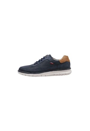Zapatilla de cuero azul marino con acento de cuero marrón en el talón, suela de goma blanca y cordones azules; cuenta con detalles de costura en contraste.