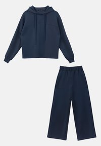 Ensemble en bleu marine comprenant un sweat à capuche assorti et un pantalon à jambes larges, avec une capuche à cordon, des poignets côtelés et des poches latérales sur le pantalon. Tissu doux et texturé.