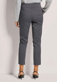 Tapered grijze broek met een ruitpatroon, met achterzakken en een slim fit ontwerp. Gekozen met zwarte hakken.