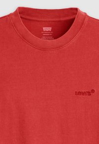 Rød bomulds sweat-shirt med rund hals, med et diskret broderet Levi's logo på brystet. Glat tekstur, vintage pasform.