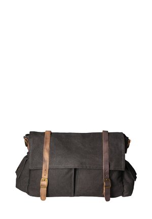 Borsa a tela scura con manici in pelle marrone, design a risvolto e tasche frontali. Presenta una texture robusta e cuciture rinforzate.