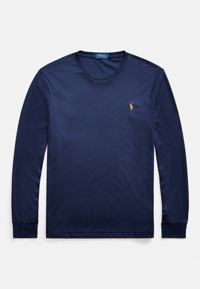 Tengerészkék hosszú ujjú póló puha pamutból, kerek nyakkivágással, bordázott mandzsettákkal és egy kis hímzett logóval a bal mellrészen.