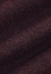 Ciemnobordowa tkanina o miękkim, teksturowanym dzianiu. Splot jest gęsty, z subtelnymi różnicami w kolorze, co wskazuje na połączone włókna.